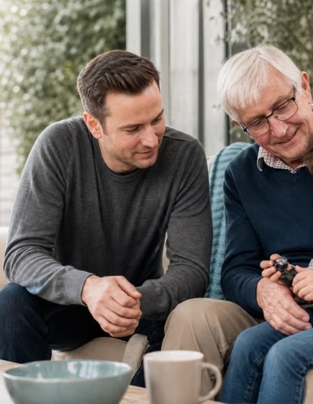 A relaxed family moment with an older parent, adult child and grandchild.